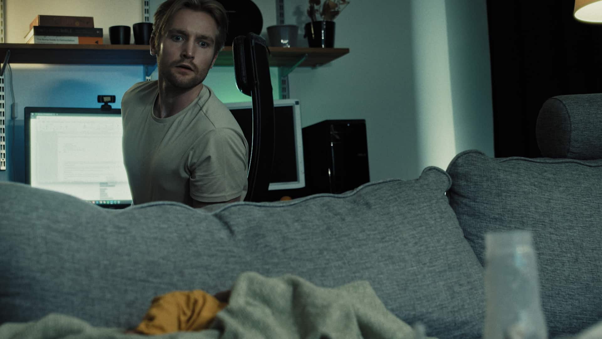 Adam sitter vid dator och kollar soffan