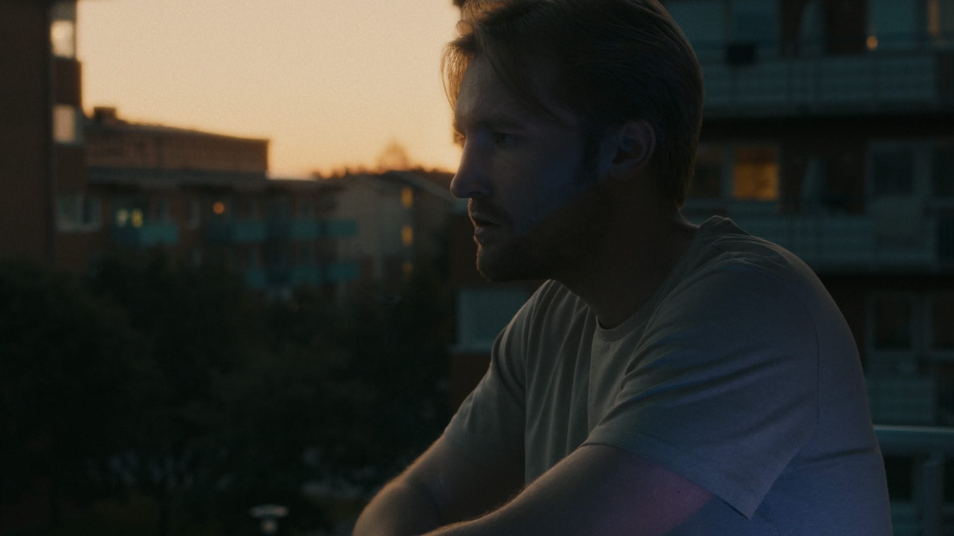Adam står på balkongen i midnattssolen